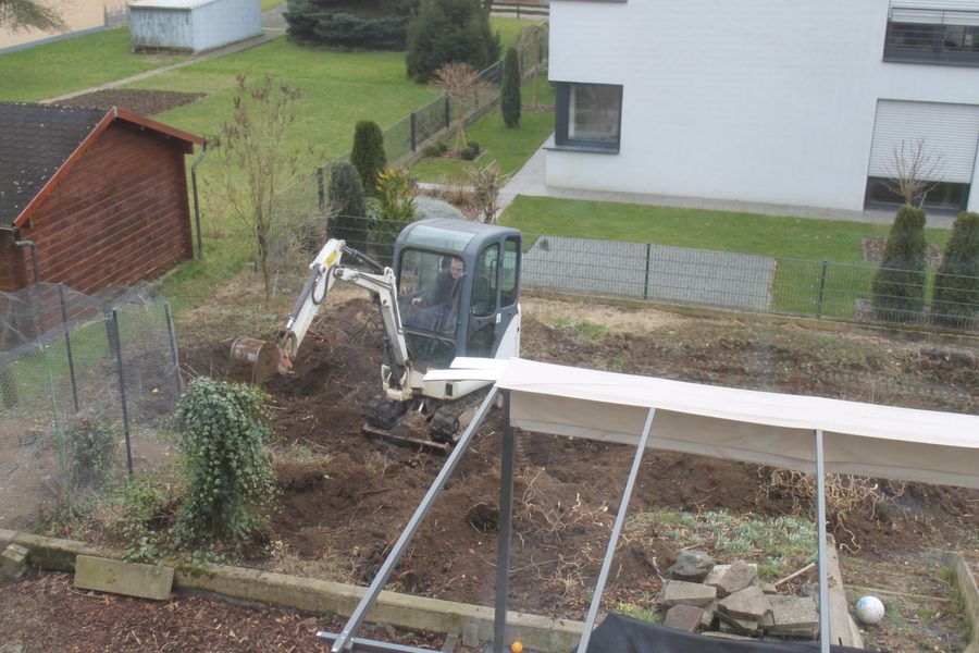 Minibagger beim Ausheben und Planieren einer Gartenfläche
