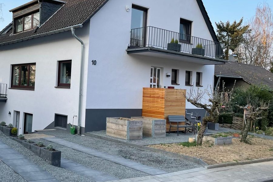 Wohnhaus mit neu angelegter Einfahrt aus Kies, Randsteinen und Hochbeeten